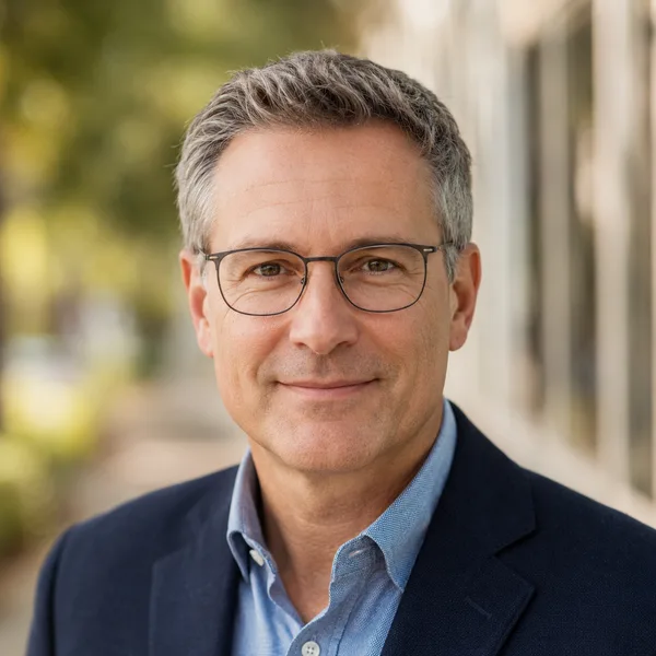 Outdoor / Natural AI headshot example — professional man in his 40s with glasses (AI-generated, not a real person)
